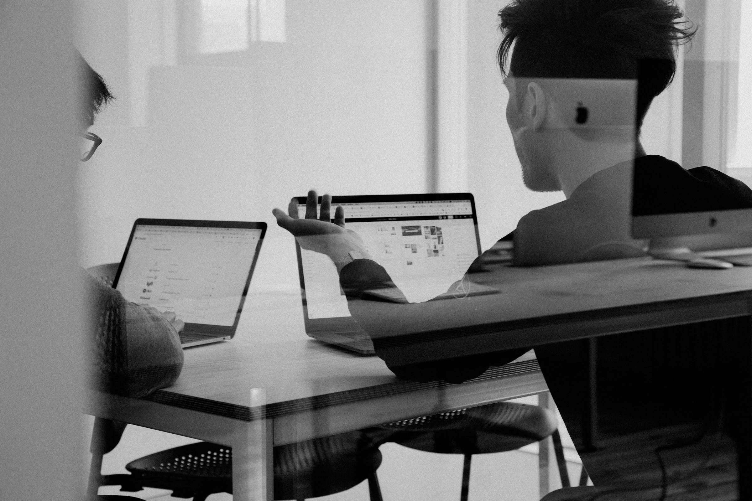 Team collaborating around a laptop in a bright workspace
